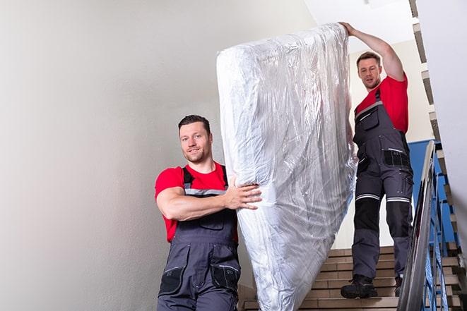 team of workers handling a box spring for disposal in Bloomdale