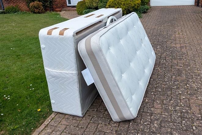 a discarded mattress being taken to a landfill